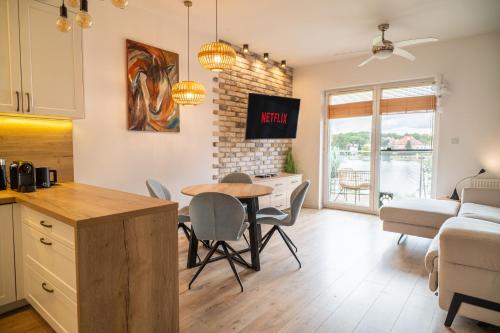 a kitchen and living room with a table and chairs at Perfect View II - idealny widok na Marinę in Iława