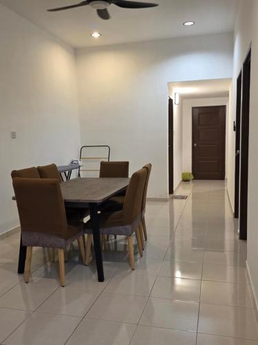 - une table à manger avec des chaises et un ventilateur de plafond dans l'établissement D'Stay Anak Dara Kijal, à Kijal