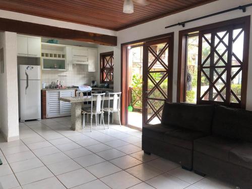 ein Wohnzimmer mit Couch und Küche in der Unterkunft Casa Maresias Canto do mar - 50m da praia in Maresias