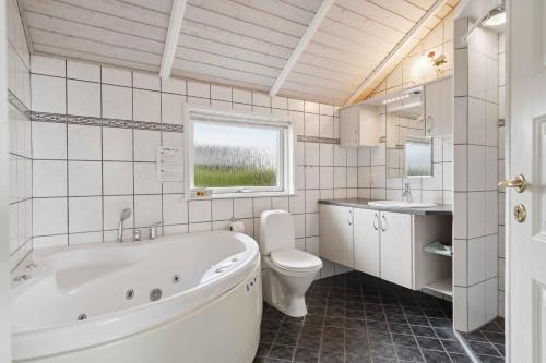 une salle de bain avec une baignoire, des toilettes et un lavabo dans l'établissement Beachside Holiday Home For The Whole Family, à Broager
