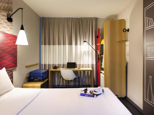 a hotel room with a bed and a desk with a computer at ibis Navegantes Itajai in Itajaí