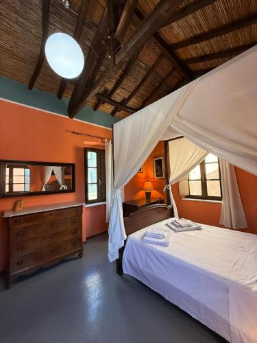 a bedroom with a bed with a dresser and a mirror at Antica Dimora in Quartu SantʼElena