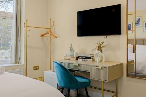 a bedroom with a desk and a tv on a wall at London Star Hotel in London