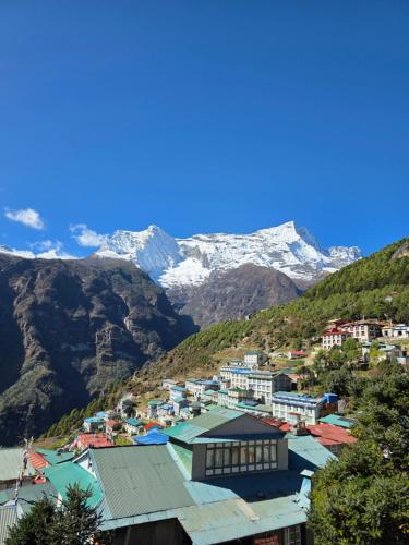 una città in montagna con montagne innevate di Tibet inn a Namche