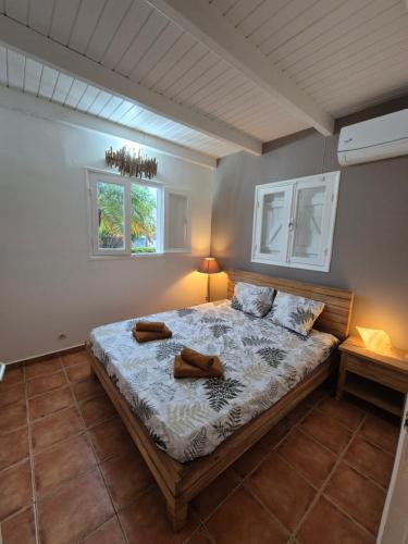 a bedroom with a bed with two shoes on it at Villa malaurelia in Saint-François