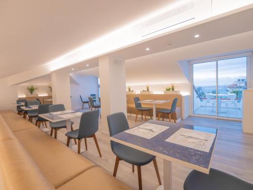 Un restaurante con mesas y sillas y un balcón. en Hotel Splendid, en Diano Marina