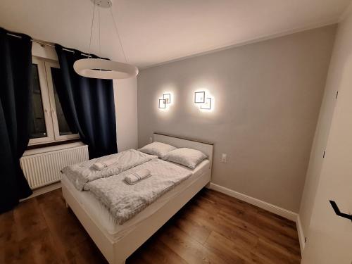 - une chambre avec un lit et deux lumières sur le mur dans l'établissement Teatralna Nowoczesny Apartament Centrum Bolesławca, à Bolesławiec