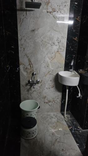 ein Marmorbad mit Waschbecken und Eimer in der Unterkunft Exit 96 Farm Stay in Pāli