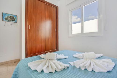 a bed with towels on top of it with a window at Villa Queen Papagayo Vetusta in Playa Blanca