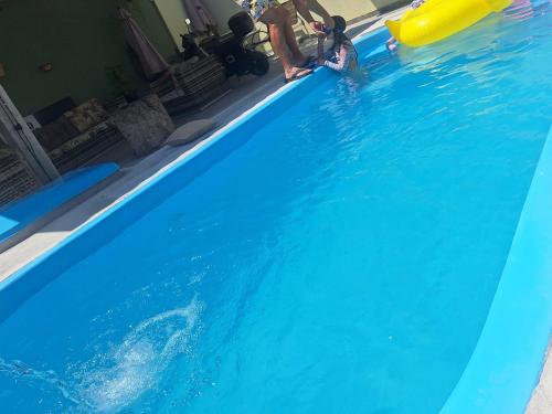 eine Gruppe von Menschen spielt in einem blauen Swimmingpool in der Unterkunft Pousada Recanto Turmalina C Piscina in Pontal do Paraná