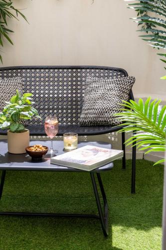 a black bench with a table and a wine glass at Hôtel Eiffel Saint Charles in Paris