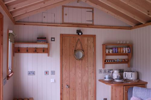 a room with a wooden door and a kitchen at Quiet Skye Winter hideaway Moluag in Portree