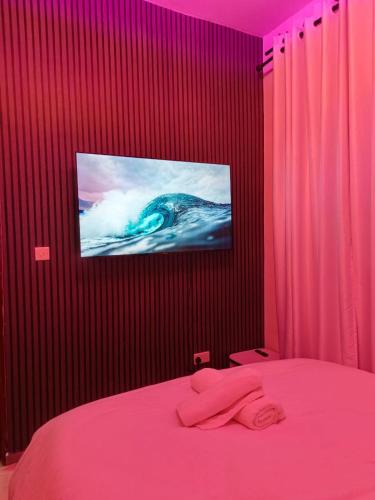 a bedroom with a pink bed with a tv on the wall at Serene luxe homes in Thika