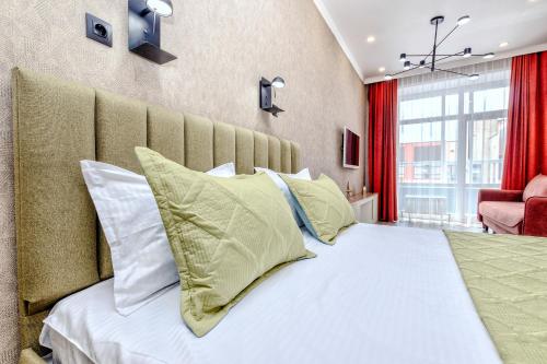 ein Schlafzimmer mit einem großen Bett und Kissen in der Unterkunft 1-комнатная квартира Кумисбекова 4, ЖК Altyn Tau in Astana