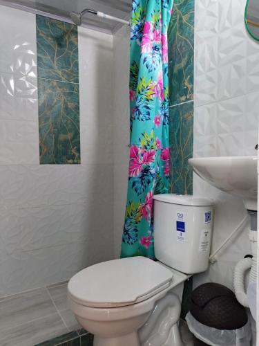 a bathroom with a toilet and a shower curtain at VaRI in Tocaima