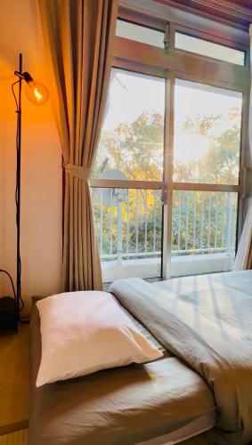 a bed in a room with a large window at FUJI Forest House203 in Gotemba