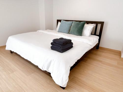 a bed with white sheets and blue towels on it at Komfort Duplex BTS Ratchayothin in Bangkok