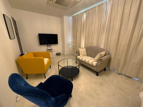 a living room with two chairs and a tv at Elena Premium Namba Stay in Osaka