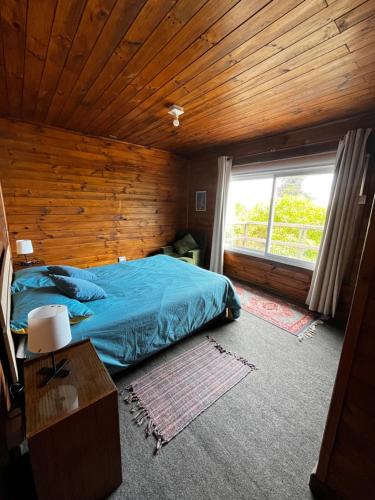 ein Schlafzimmer mit einem blauen Bett und einem Fenster in der Unterkunft Casa en algarrobo con hermosa vista al mar in Algarrobo