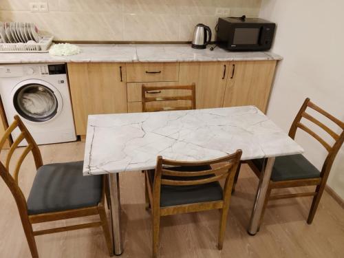 a white marble table and chairs in a kitchen at cozy haven hostel in Aghk'ilisa