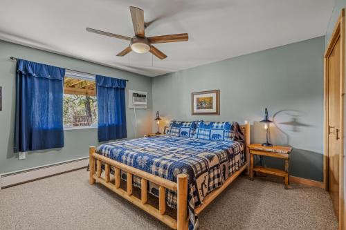 Un dormitorio con una cama y un ventilador de techo. en Camp Dancing Bears - Wifi, Riverfront, Pet Friendly, Fire Pit, Grill, Deck, Fishing, Games, Fireplace, King Bed, en Morton Grove