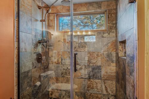 Un baño con ducha con puerta de cristal en Camp Dancing Bears - Wifi, Riverfront, Pet Friendly, Fire Pit, Grill, Deck, Fishing, Games, Fireplace, King Bed, en Morton Grove