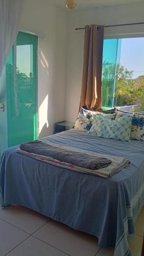 a bedroom with a blue bed with a window at Araruama junto a Lagoa - Centro in Araruama