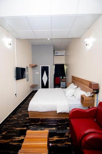 a bedroom with a bed and a red couch at LINKS Bed and Breakfast in Abeokuta