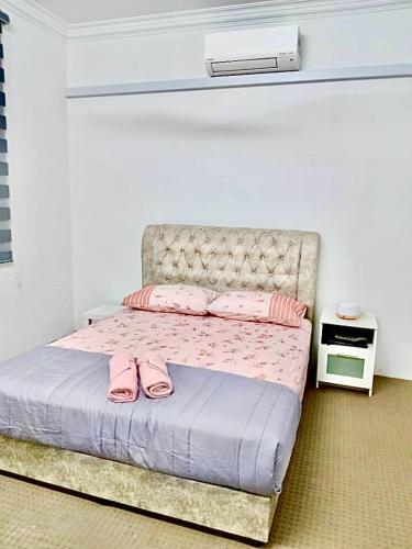 a bedroom with a bed with pink shoes on it at ILHAM homestay in Kota Bharu