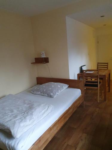 Bett in einem Zimmer mit einem Tisch und einem Stuhl in der Unterkunft Auf dem Bauernhof 