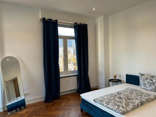 a bedroom with a bed and a large window at Petit Chatelet Rooms in Saarbrücken