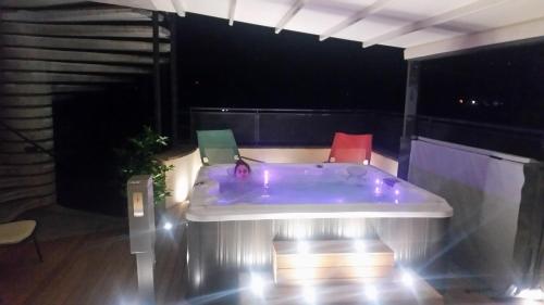 a person sitting in a jacuzzi tub on a balcony at night at Hotel Fondovalle in Città della Pieve