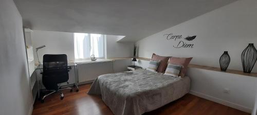 a bedroom with a bed and a desk and a chair at Maison confortable 6 personnes - 3 chambres - Espaces partagés in Saint-Sauvant