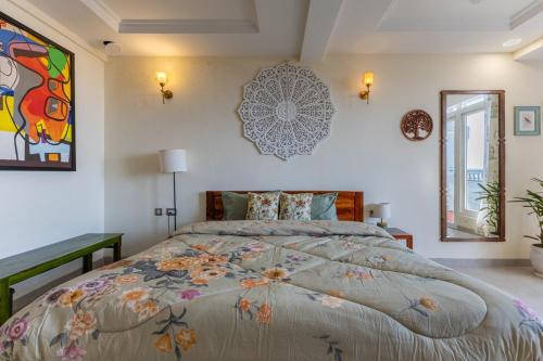 a bedroom with a large bed and a painting on the wall at The Sky Penthouse - Mussoorie Rd Da Alohas Retreat in Dehradun