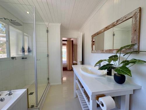 克尼斯纳Lagoonside Lookout的浴室设有2个水槽、淋浴和盆栽植物