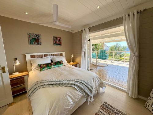克尼斯纳Lagoonside Lookout的一间卧室，里面有一张床和一扇推拉玻璃门