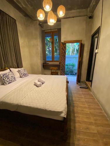 a bedroom with a bed with two towels on it at Kubu Nadhi in Ketewel