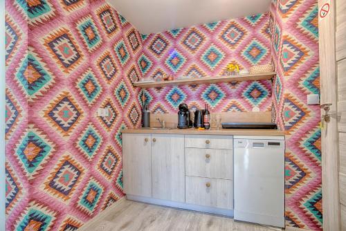 a kitchen with a colorful patterned wall at Pod Wodospadem in Szczyrk
