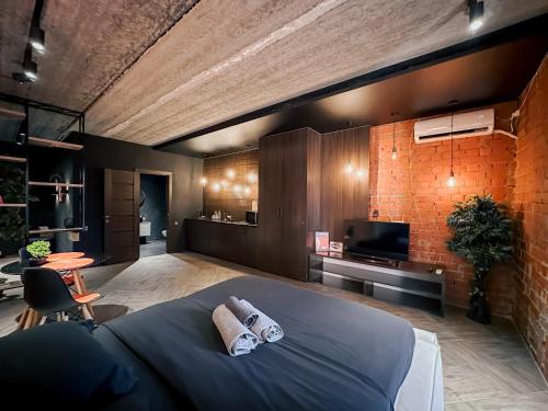 a bedroom with a bed with two towels on it at Люкс в стиле LOFT in Pavlodar