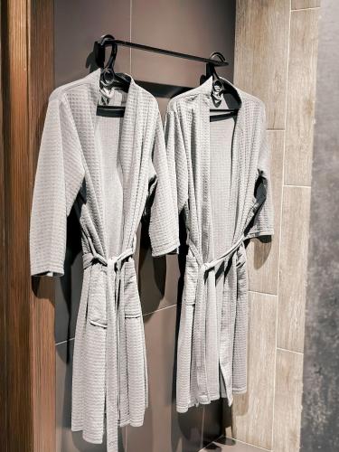two white towels hanging on a rack in a bathroom at Люкс в стиле LOFT in Pavlodar