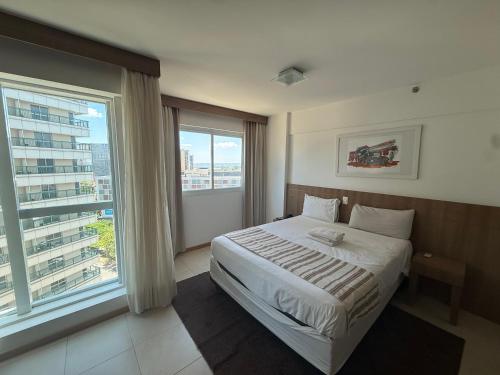 ein Schlafzimmer mit einem Bett und einem großen Fenster in der Unterkunft Saint Moritz Hotel - ALM hospedagens - Flat Particular 2 in Brasilia
