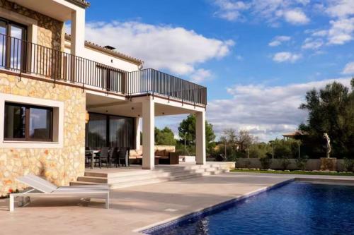 a villa with a swimming pool and a house at Trebol in Sa Pobla