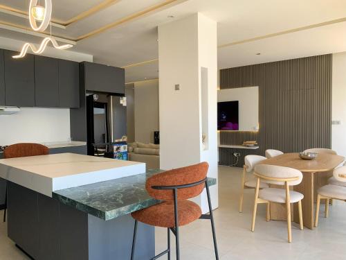 a kitchen and dining room with a table and chairs at la Villa WOOR Saly Joseph in Mbour