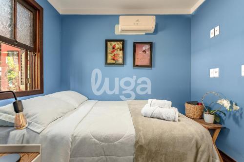 a bedroom with a blue wall with a bed at Vieira Eco Inn – Standard Suite in Orleans