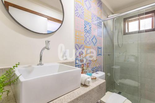 ein Badezimmer mit Waschbecken, Dusche und Spiegel in der Unterkunft Vieira Eco Pousada #1 in Orleans