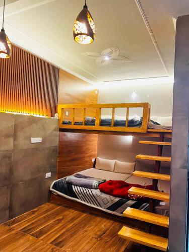 a bedroom with two bunk beds and wooden floors at Bhoora House in Jaipur