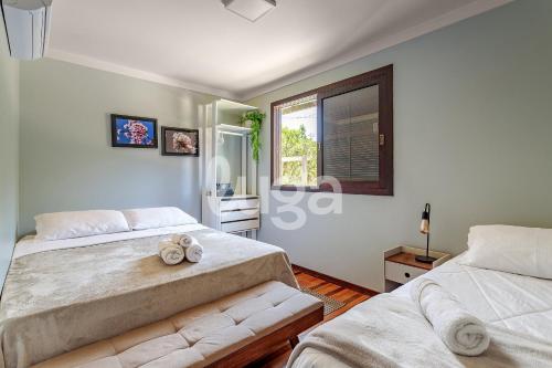 ein Schlafzimmer mit zwei Betten und einem Fenster in der Unterkunft Vieira Eco Pousada #2 in Orleans