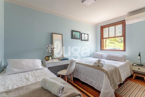 a bedroom with two beds and a desk and a window at Vieira Eco Inn – Deluxe Suite Vanio #2 in Orleans