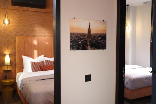 a room with two beds and a picture of the eiffel tower at De Oranjestad - In de winkelstraat in Breda
