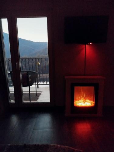 a room with a fireplace with a view of a balcony at Vila Lena in Međuvršje